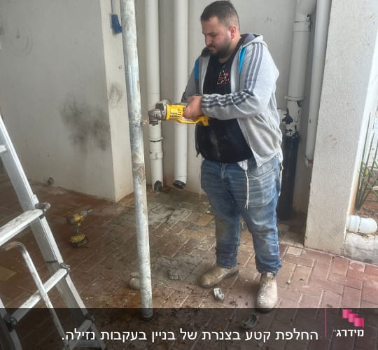 אדם חותך צינור מתכת עם מסור חשמלי